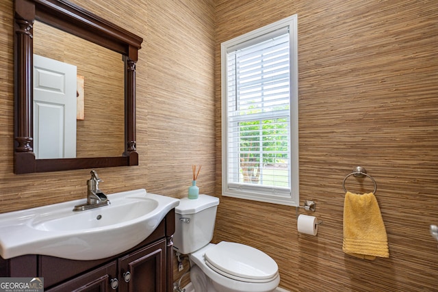 half bath featuring vanity and toilet