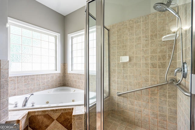 bathroom with a tub with jets and a stall shower