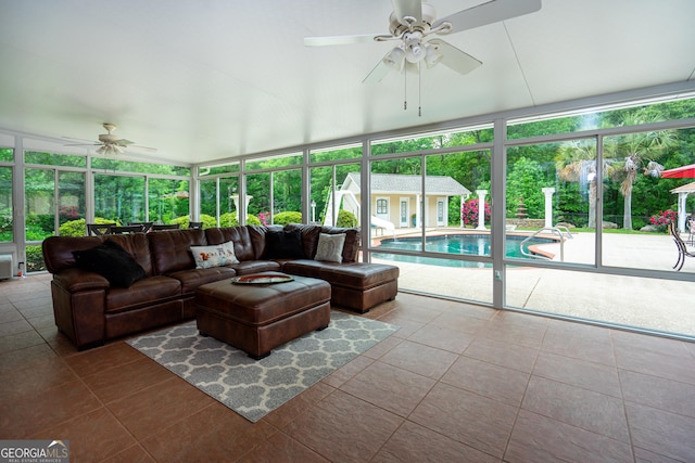 tiled living room featuring a ceiling fan and floor to ceiling windows