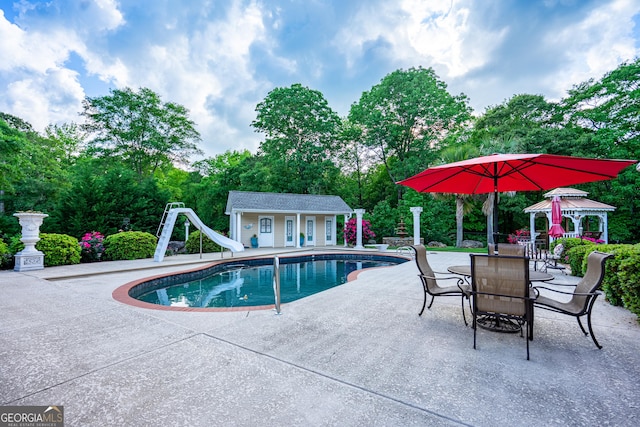 pool featuring an outdoor structure, a patio, an exterior structure, a gazebo, and a water slide