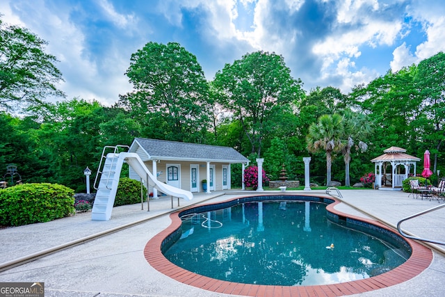 pool with a patio, a gazebo, an outbuilding, and a water slide