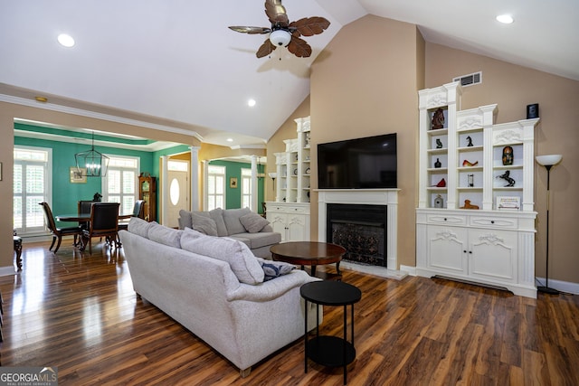 living area featuring visible vents, lofted ceiling, ornate columns, a fireplace with raised hearth, and a ceiling fan