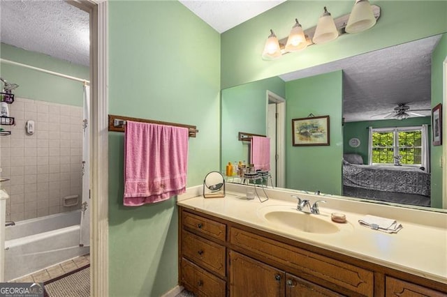 bathroom featuring vanity, ceiling fan, a textured ceiling, tile patterned floors, and ensuite bath