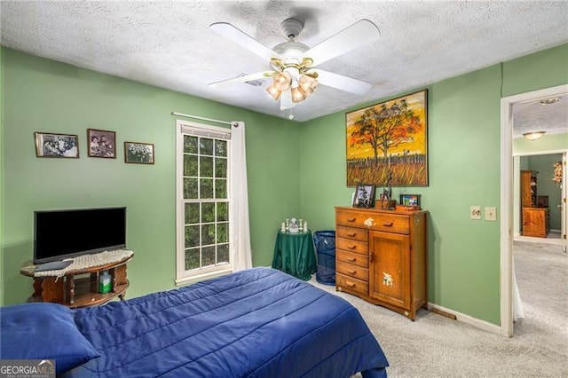 carpeted bedroom with a textured ceiling, ceiling fan, and baseboards