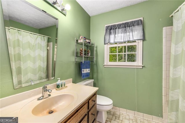 bathroom featuring toilet, a textured ceiling, a shower with curtain, and vanity
