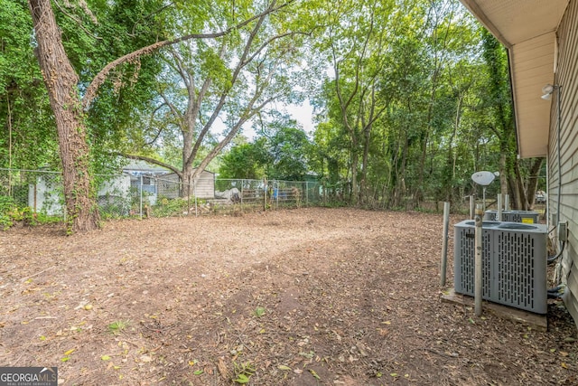 view of yard featuring fence and central AC unit