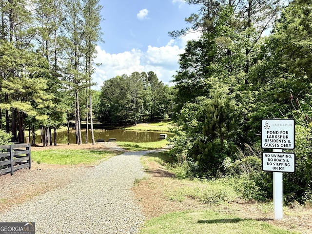 view of property's community with fence and a water view