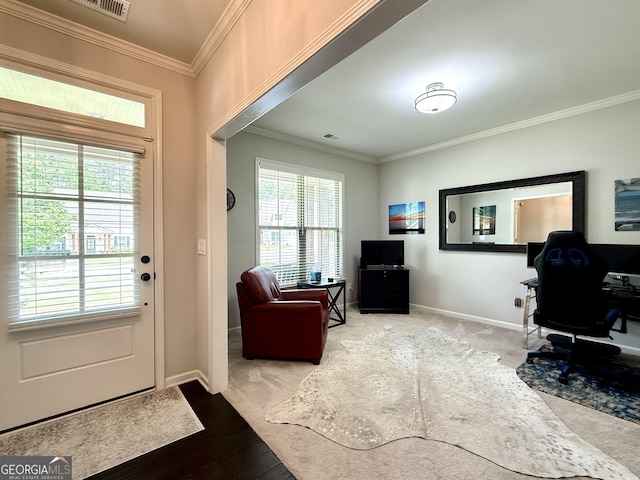 interior space featuring crown molding, baseboards, visible vents, and wood finished floors