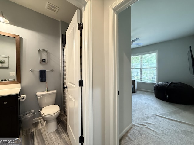 bathroom with vanity, baseboards, toilet, and visible vents