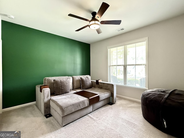 living area with carpet floors, baseboards, visible vents, and ceiling fan