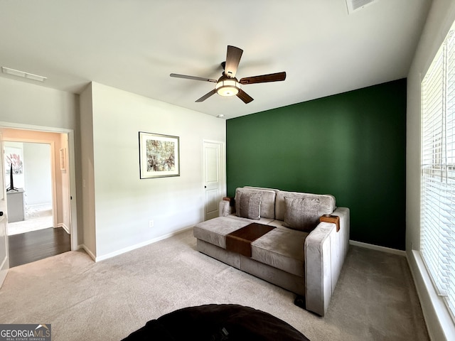 carpeted living room featuring ceiling fan, visible vents, and baseboards