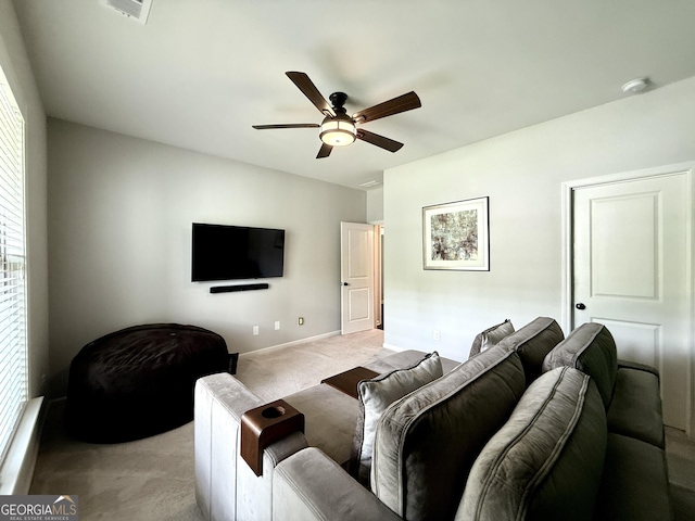 living area featuring ceiling fan, light colored carpet, baseboards, a healthy amount of sunlight, and visible vents