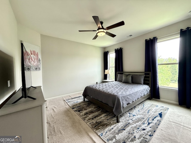 bedroom featuring baseboards, visible vents, and light carpet
