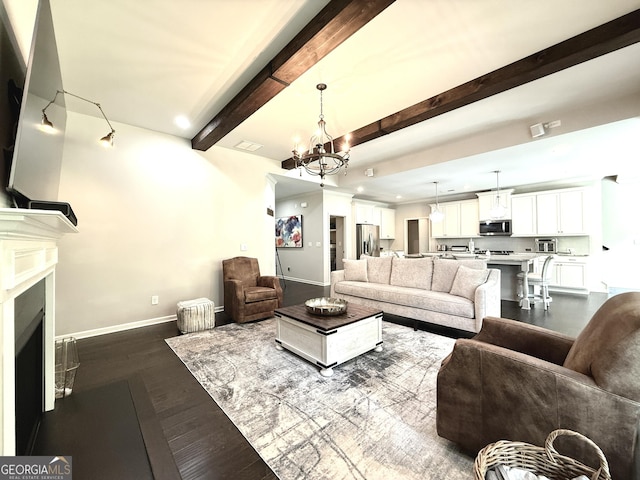 living area with baseboards, a chandelier, dark wood finished floors, and beam ceiling