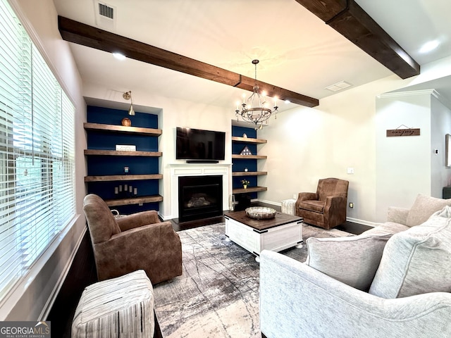 living area with visible vents, a notable chandelier, a fireplace, and beamed ceiling