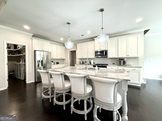 kitchen featuring ornamental molding, stainless steel appliances, recessed lighting, and white cabinets