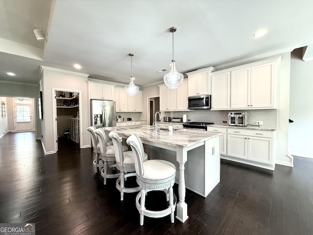 kitchen featuring white cabinets, appliances with stainless steel finishes, and ornamental molding