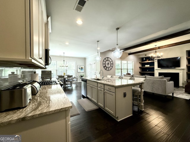 kitchen with pendant lighting, a breakfast bar, a chandelier, a sink, and appliances with stainless steel finishes