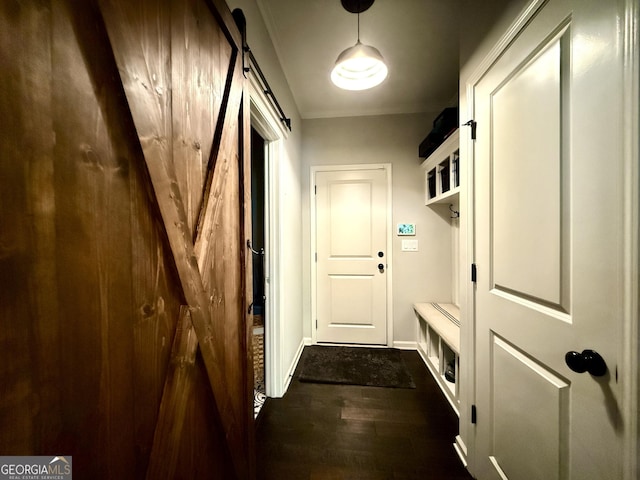 mudroom with baseboards, a barn door, and dark wood-style flooring