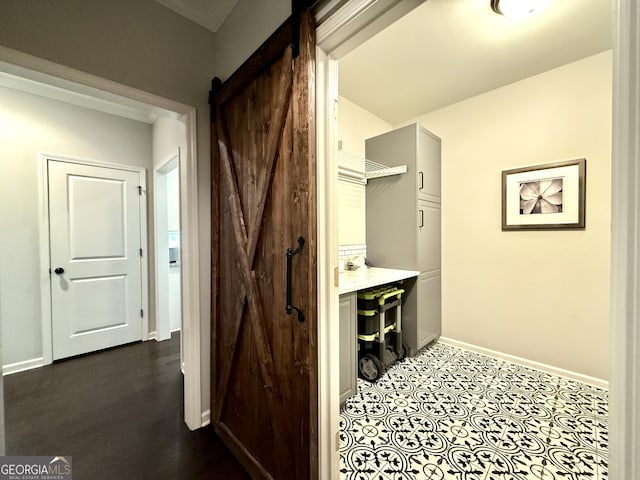 hall with baseboards and a barn door