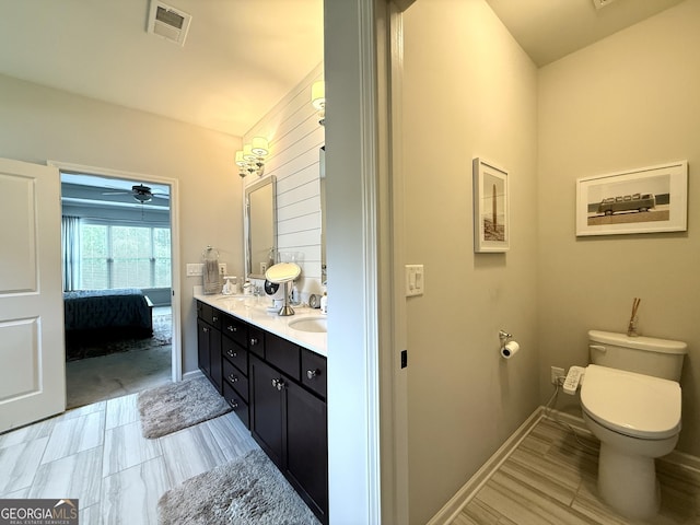 ensuite bathroom with visible vents, double vanity, toilet, ensuite bathroom, and ceiling fan