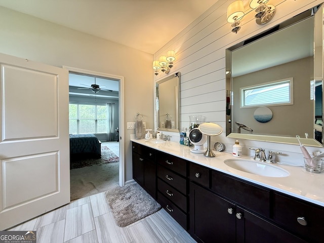 ensuite bathroom featuring double vanity, a sink, connected bathroom, and ceiling fan