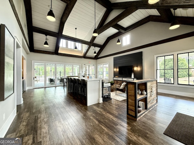 living area featuring baseboards, a healthy amount of sunlight, high vaulted ceiling, and dark wood-style floors