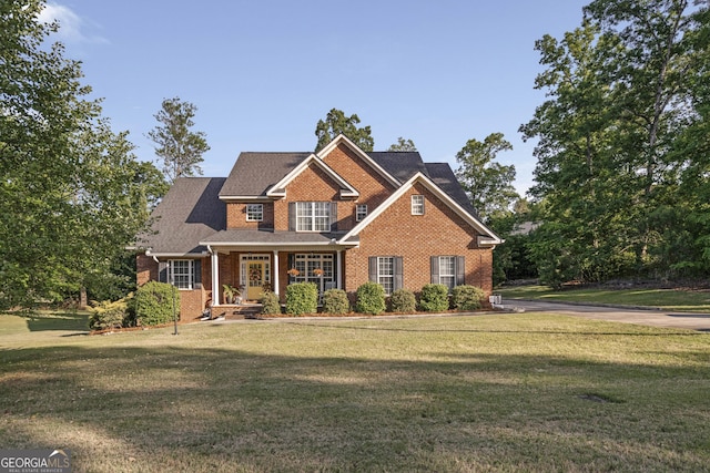 craftsman inspired home featuring brick siding, roof with shingles, covered porch, and a front yard
