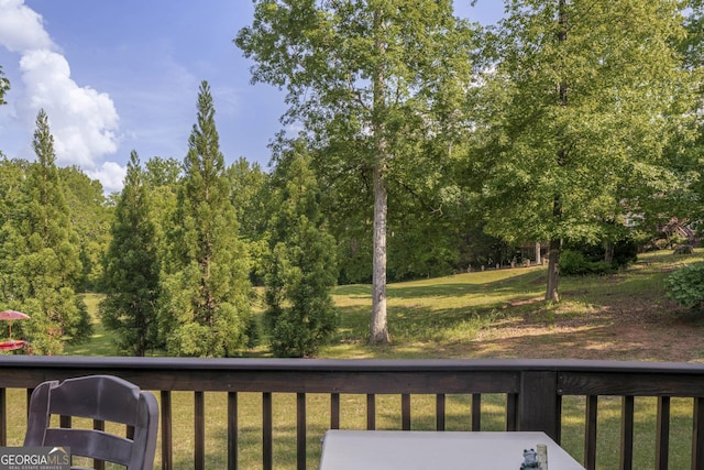 wooden deck featuring a lawn