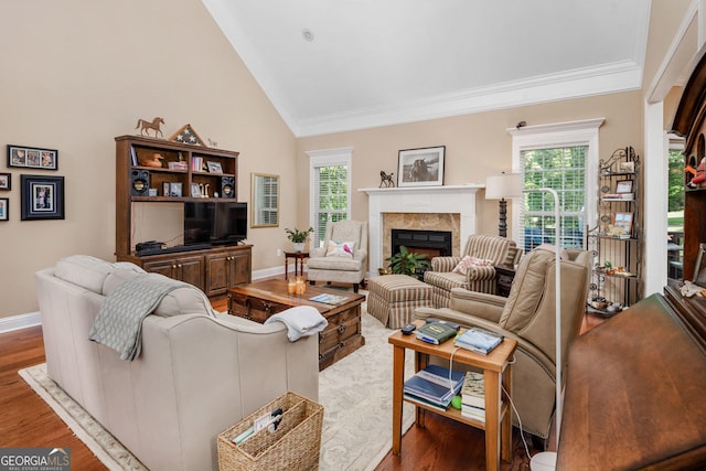 living room with ornamental molding, a fireplace, vaulted ceiling, and wood finished floors