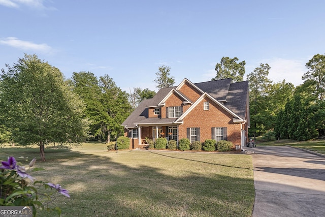 craftsman-style home with brick siding, a front yard, and concrete driveway