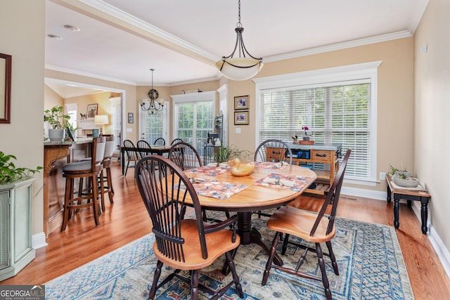 dining space featuring crown molding, baseboards, a chandelier, and light wood-style flooring