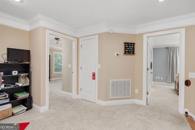 hallway featuring visible vents, carpet flooring, and ornamental molding