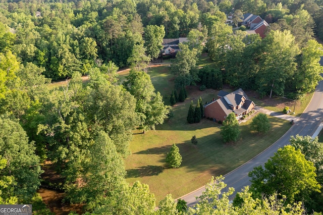 bird's eye view with a wooded view
