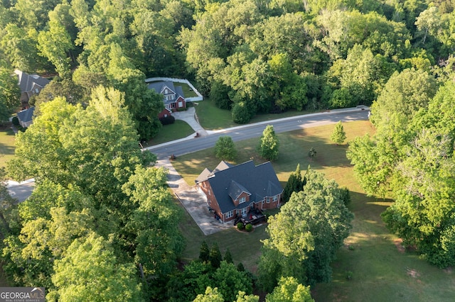 drone / aerial view featuring a wooded view