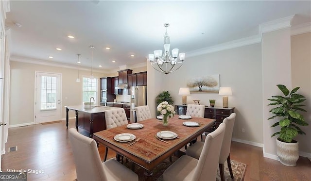 dining area featuring a chandelier, wood finished floors, ornamental molding, baseboards, and recessed lighting