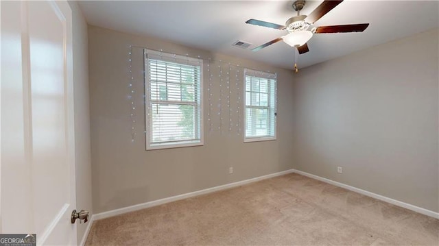 unfurnished room with light colored carpet, baseboards, and ceiling fan