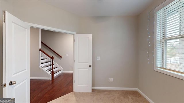 unfurnished room with baseboards and stairway