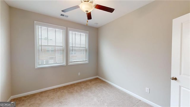 empty room featuring light carpet, baseboards, and ceiling fan