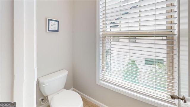 bathroom featuring baseboards and toilet