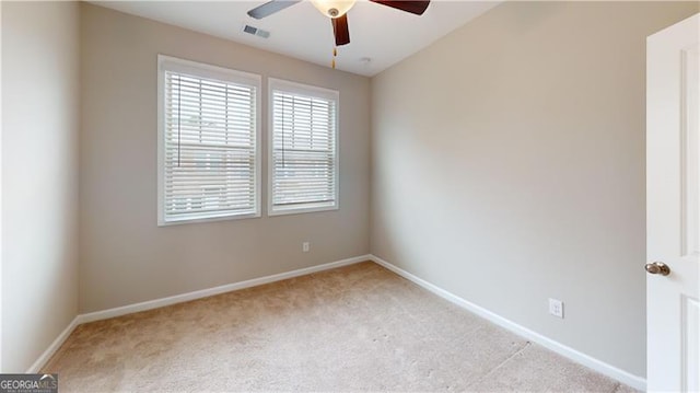 empty room with carpet floors, a ceiling fan, and baseboards