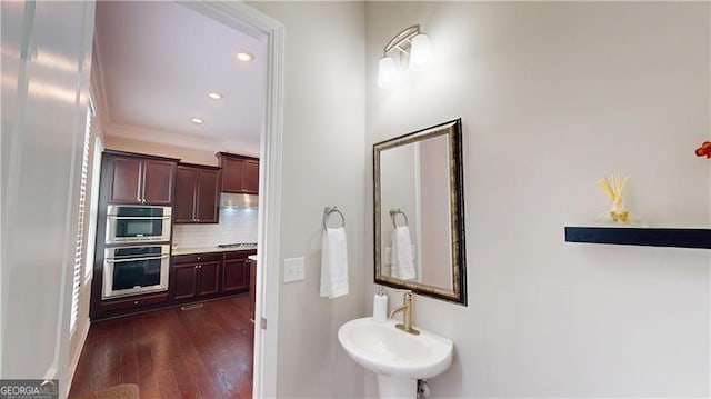 bathroom featuring tasteful backsplash, a sink, hardwood / wood-style flooring, and recessed lighting