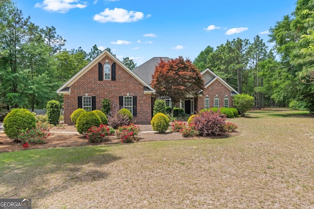 view of front of home featuring brick siding and a front lawn