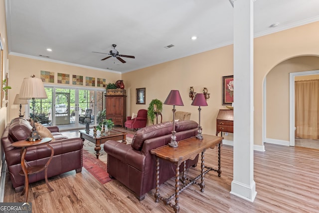 living room featuring crown molding, ceiling fan, visible vents, and light wood-style floors