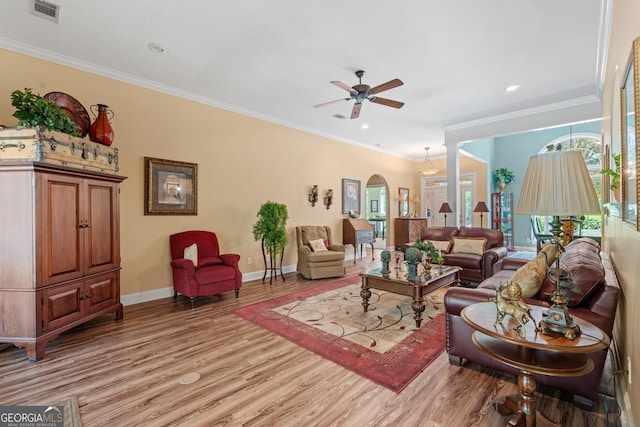 living room with ceiling fan, light wood-style floors, arched walkways, baseboards, and visible vents