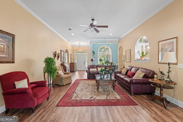 living room featuring arched walkways, baseboards, ceiling fan, and wood finished floors