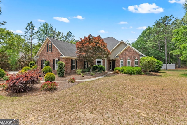 view of front of property featuring brick siding and a front lawn