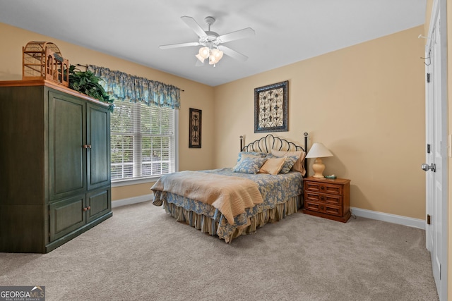 bedroom featuring baseboards, a ceiling fan, and light carpet
