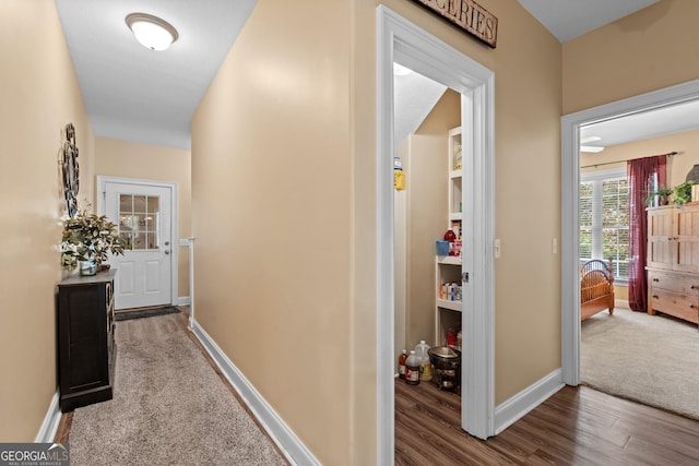 hall with baseboards and wood finished floors