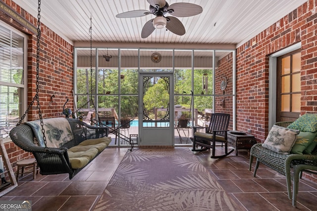 sunroom / solarium featuring ceiling fan and a wealth of natural light